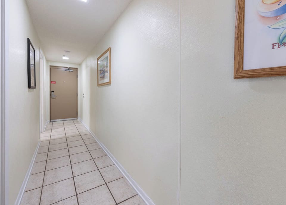 Step into a welcoming hallway adorned with artwork, leading you to your beachfront vacation retreat