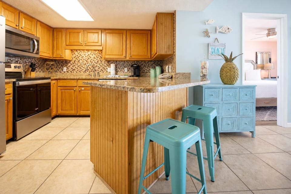 Wood cabinetry and granite countertops define this kitchen area, featuring a stylish backsplash and Keurig coffee maker