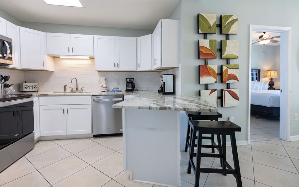 Prepare meals and enjoy drinks at the stylish breakfast bar, surrounded by vibrant leaf artwork and a welcoming vibe