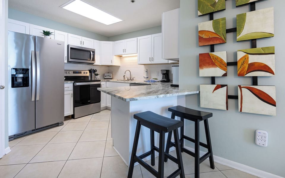 Enjoy cooking in this stylish kitchen with stainless appliances, marbled counters, and sleek cabinetry