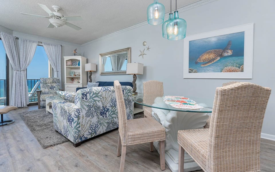Unwind in the inviting living space featuring coastal decor, a glass dining table, and views of the beach