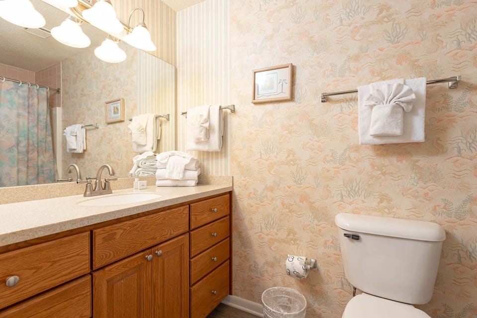 Refresh in this guest bath featuring a spacious vanity, soft towels, and a cheerful coastal shower curtain