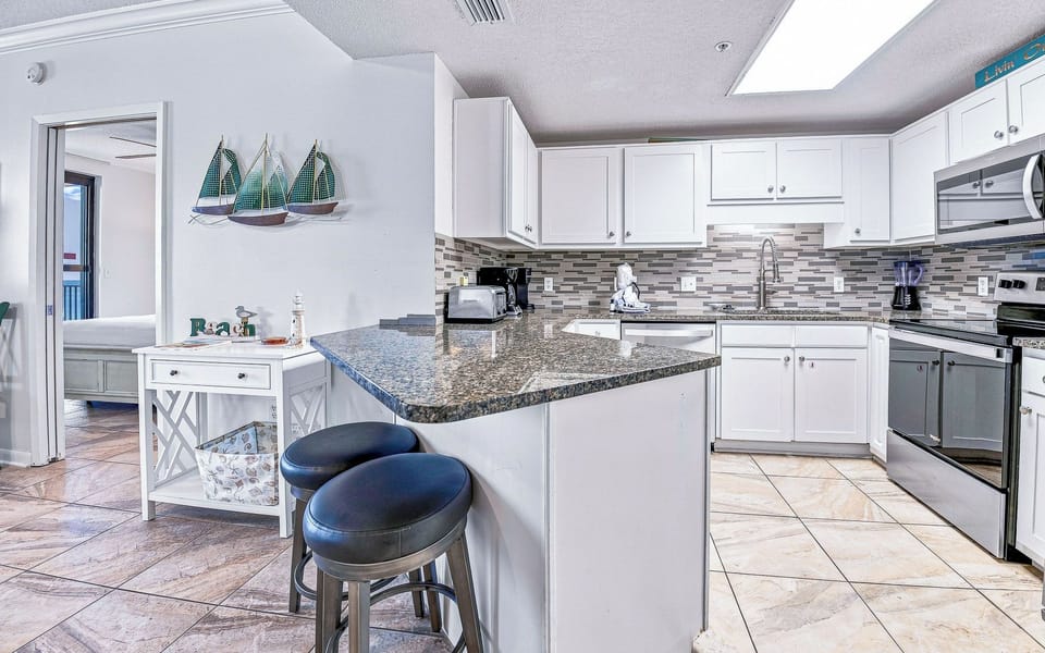 Smooth granite breakfast bar invites casual mornings filled with coffee aromas and quiet moments in the kitchen