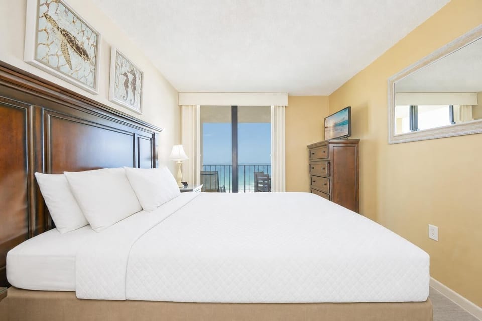 Plush king bed and soothing coastal artwork set the tone for restful nights in your master suite