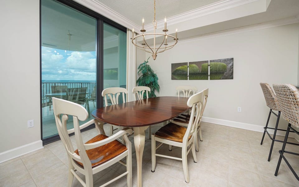 Gather around the elegant dining table, enjoying views through large glass doors that lead to the beachfront balcony