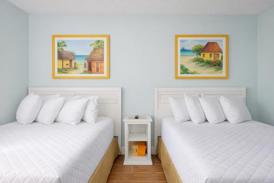 Experience restful nights on plush bedding in this cheerful guest room, enriched by vibrant coastal artwork