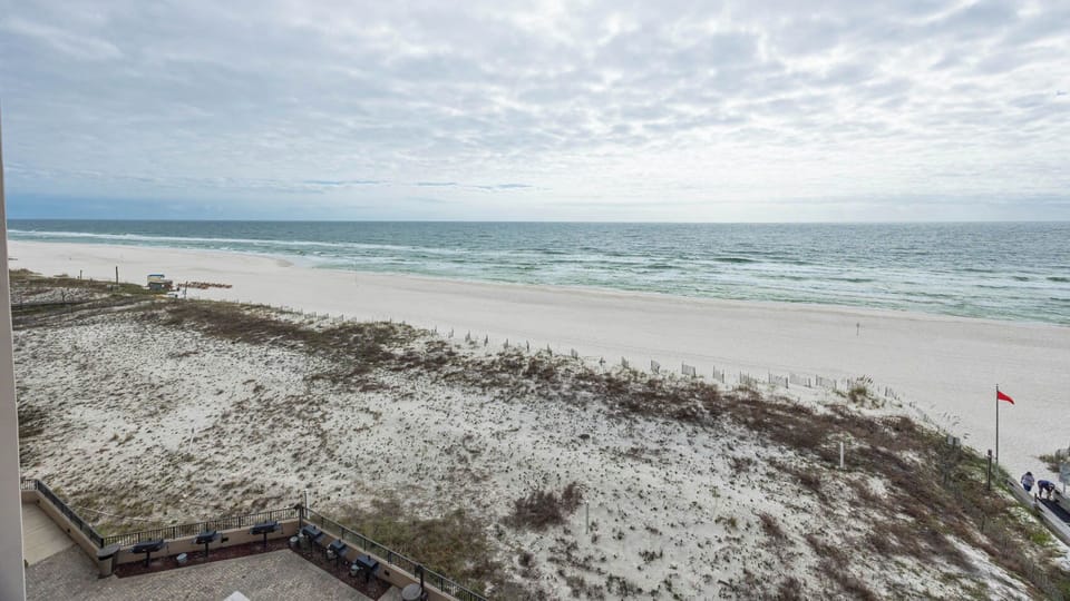Gaze at the tranquil waters and soft shoreline from your comfortable balcony, perfect for relaxation and enjoyment