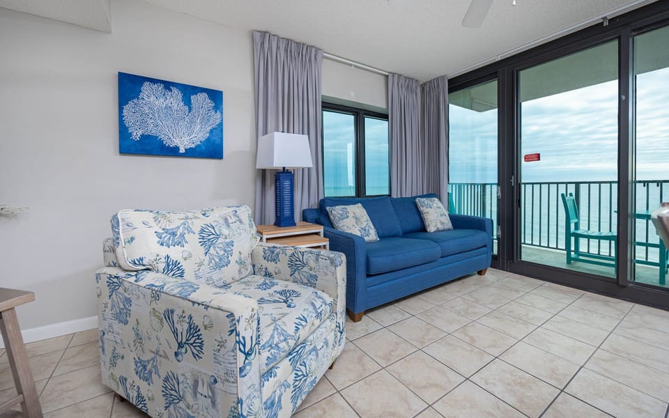 Unwind in the inviting living area with comfortable seating and large windows showcasing beautiful beach views