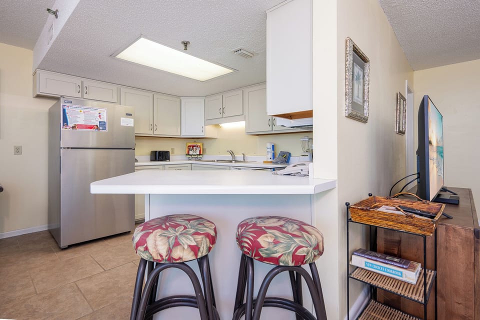 Floral stools invite you to sip drinks at the breakfast bar while the kitchen buzzes quietly nearby