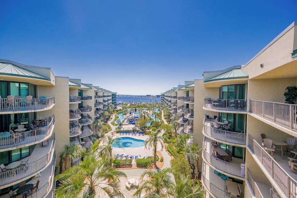 Relax on the balcony, soaking in the stunning views and vibrant atmosphere of the lush grounds and inviting pools below
