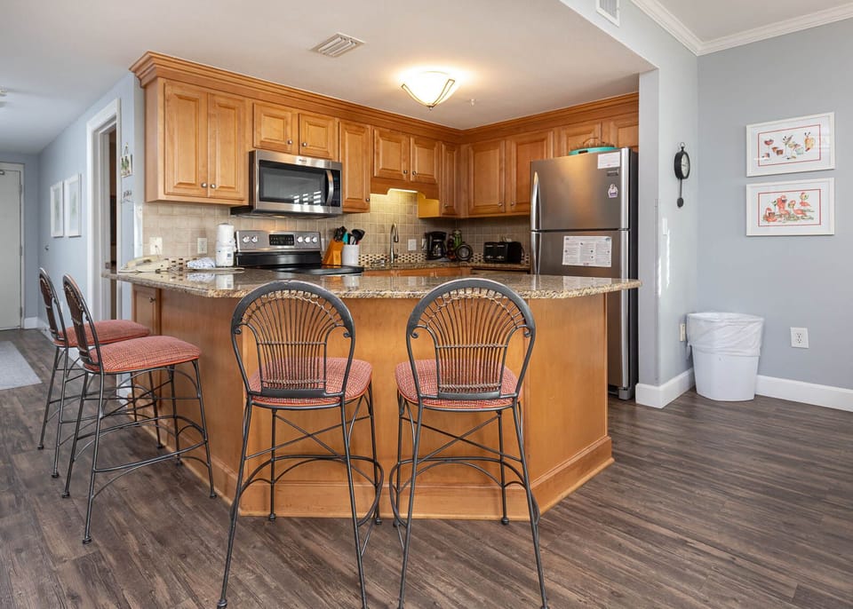Gather around the inviting breakfast bar with stylish seating, perfect for meals and conversation