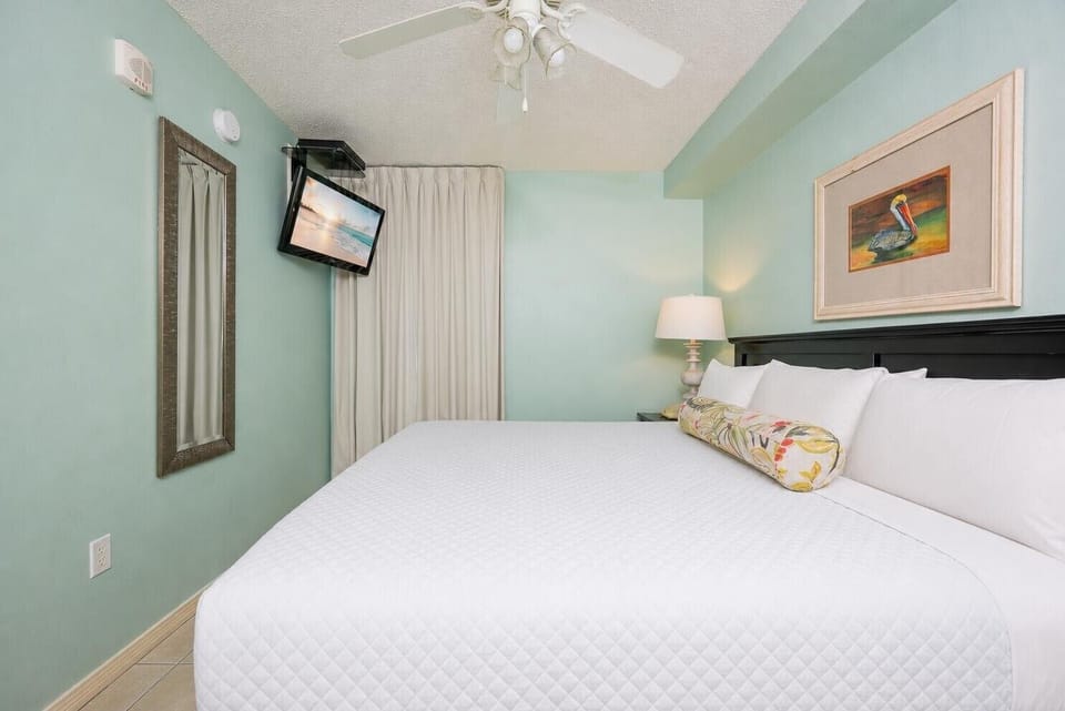 Fluffy pillows invite you to relax in the king suite for a calm movie night after a fun day at the beach