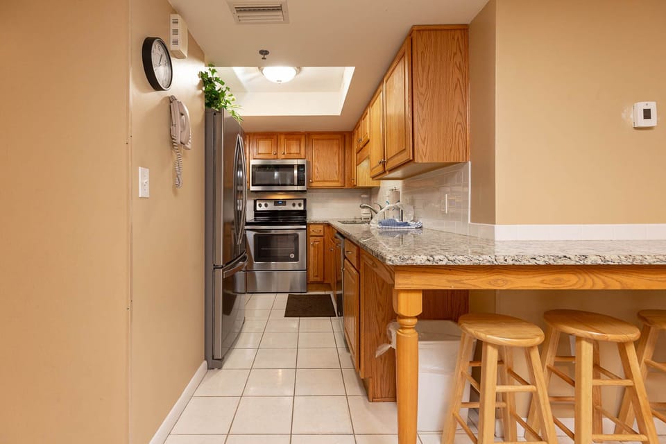 Inviting kitchen featuring stainless appliances, granite countertops, and cozy bar stools for casual dining