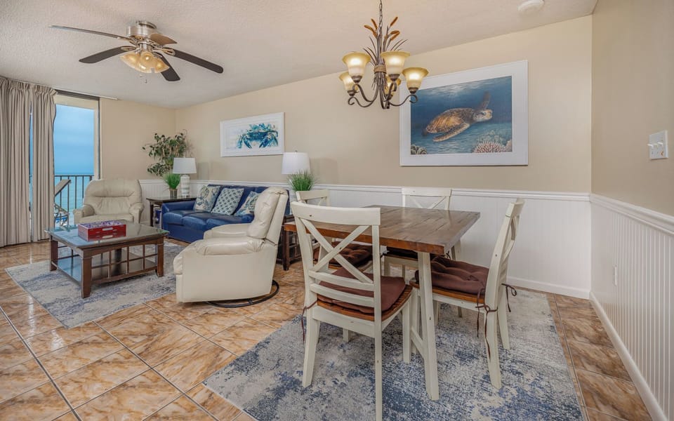 In the living room, you sink into cushioned chairs while glimpsing the gulf through sliding glass doors