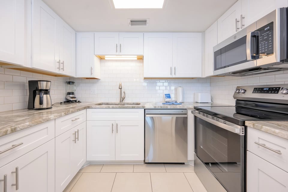 Prepare meals in this stylish kitchen featuring sleek countertops, stainless appliances, and elegant cabinetry