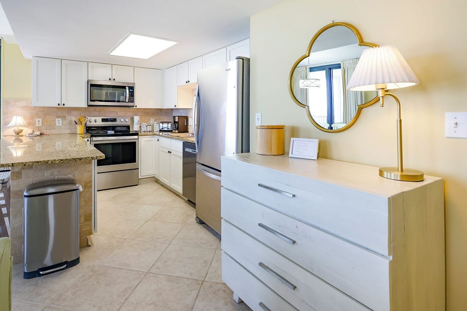 Stylish kitchen features granite countertops, white cabinetry, and a convenient breakfast bar with seating
