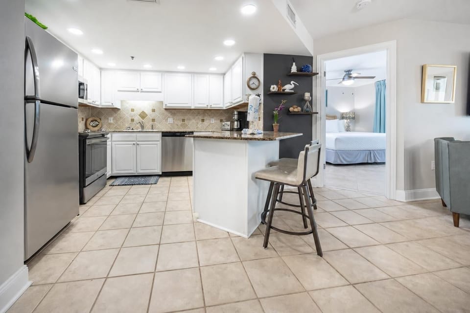 Modern kitchen featuring granite countertops, stainless appliances, and a breakfast bar with seating