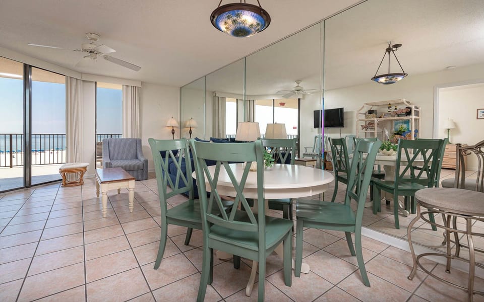 Gather around the round dining table, enjoying beachfront views that invite natural light into the space
