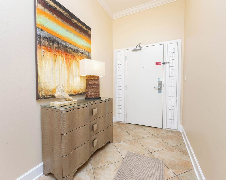 Brightly decorated entryway featuring a stylish console table, modern lamp, and vibrant artwork, welcoming you home