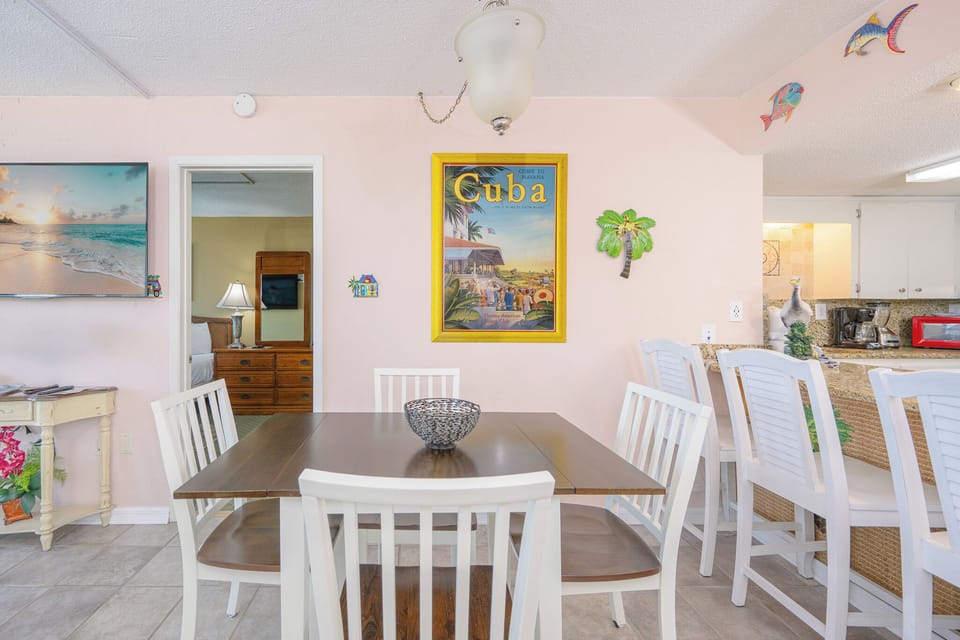 Sit together at the dining table, enjoying friendly conversation amidst colorful beach-themed decor