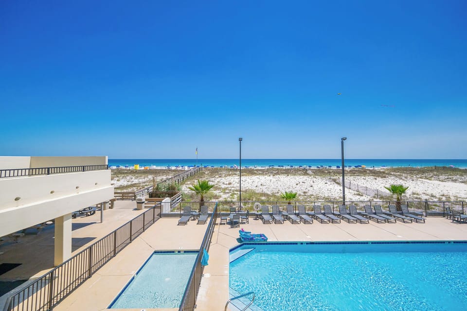Relax in the inviting pool area, soaking up the sun while enjoying views of the beach just steps away