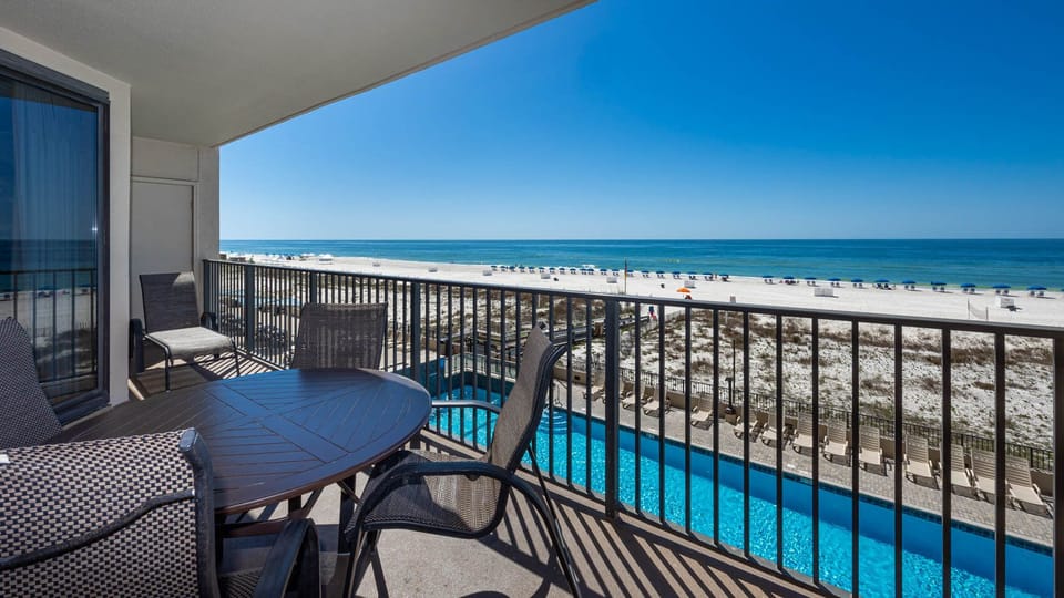 Savor meals or relax on the balcony with comfortable seating and views of the beach and inviting pool below