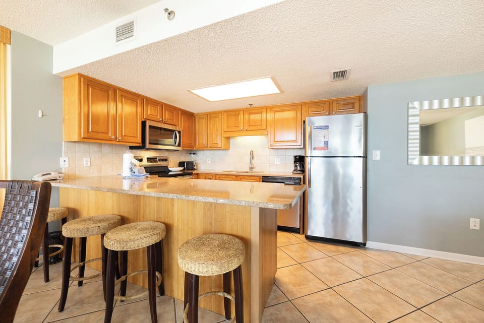 Prepare fresh beachside meals at your kitchen's bright breakfast bar with woven stools for casual gatherings