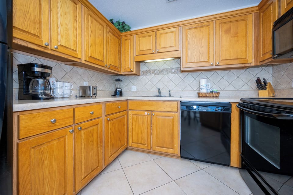 Kitchen with warm wood cabinetry, a coffee maker, and a sleek breakfast bar area for convenient entertaining