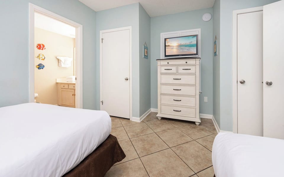 Inviting guest room featuring two double beds, a TV, and cheerful decor that enhances your stay