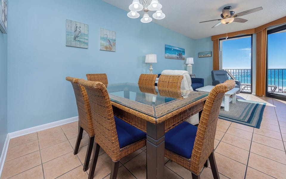 Dine at the glass-top table with wicker chairs, while enjoying views of the shimmering water and inviting decor