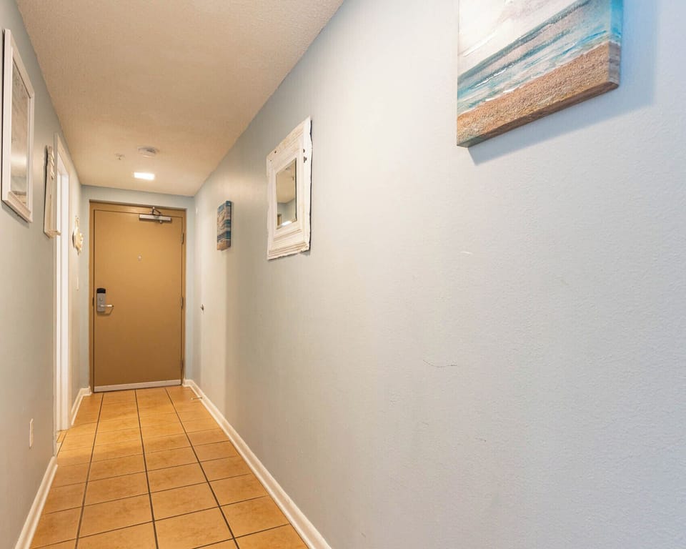 Step into a welcoming hallway adorned with beach-themed decor, leading you to your vacation retreat