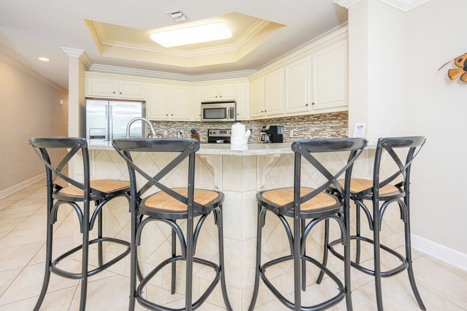Gather around the spacious bar, sipping your favorite drinks while sharing joyful conversations in this welcoming kitchen