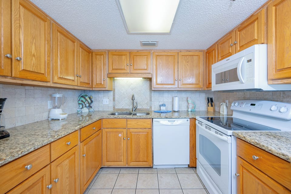 Warm wood cabinets surround you as you prepare fresh meals and enjoy the coastal vibe