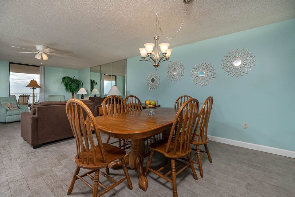Dine comfortably at the wooden table surrounded by charming decor and a welcoming living area