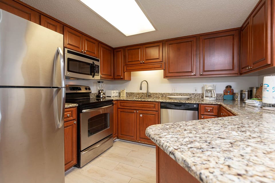 Granite countertops and stainless appliances in this well-equipped kitchen, featuring ample space for coastal meal prep