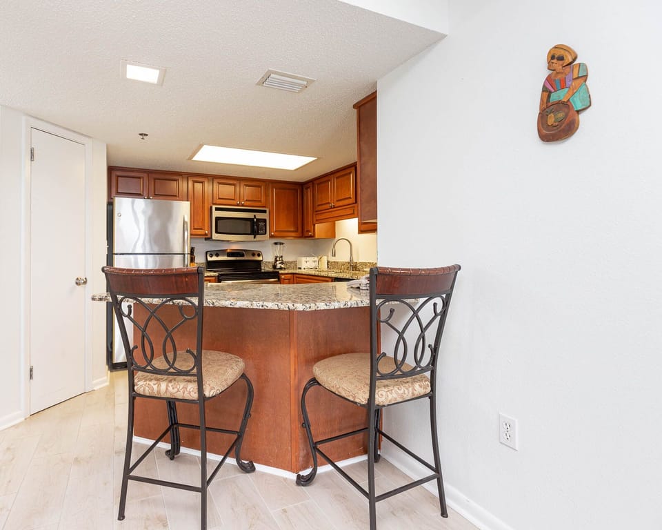 Warm wood cabinetry complements the granite countertops in this inviting kitchen area with bar seating for casual dining