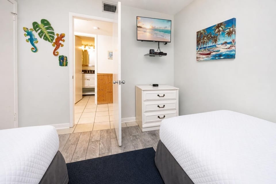 Settle in with coastal art and watch your favorite shows in this guest suite with two twin beds