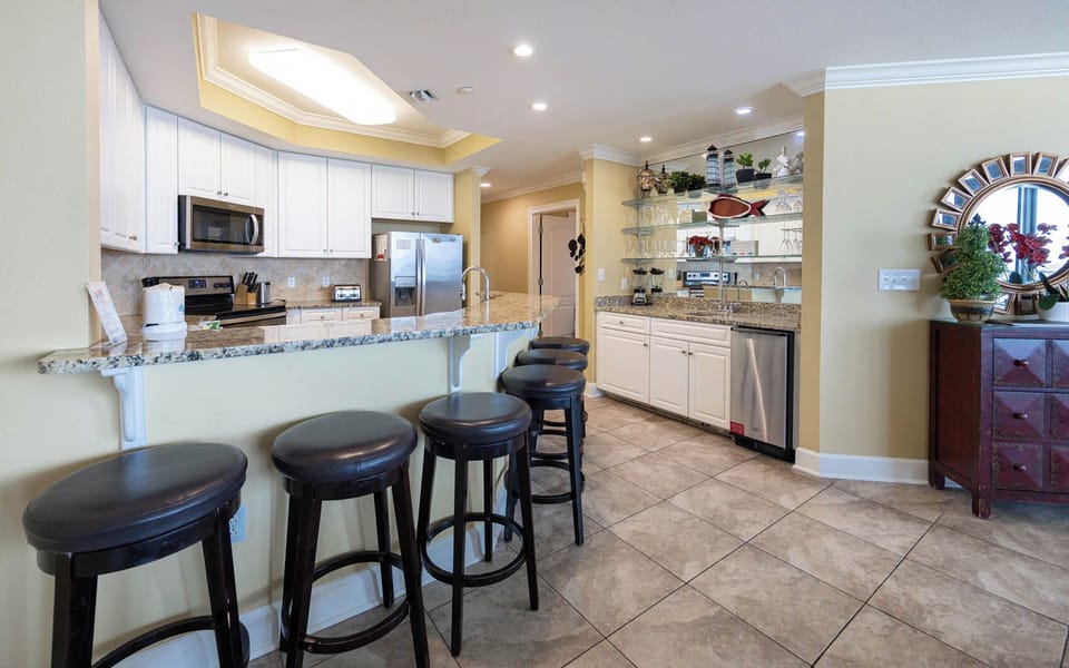 Kitchen with granite countertops, stainless appliances, and stylish seating for a perfect vacation gathering