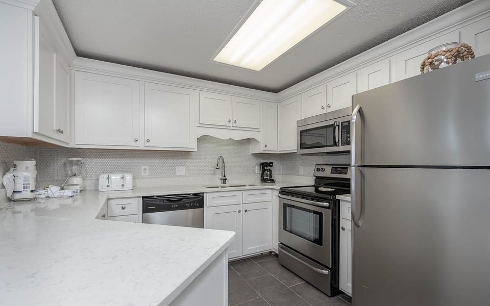 Prepare delicious meals in the sleek kitchen featuring stainless steel appliances and elegant countertops