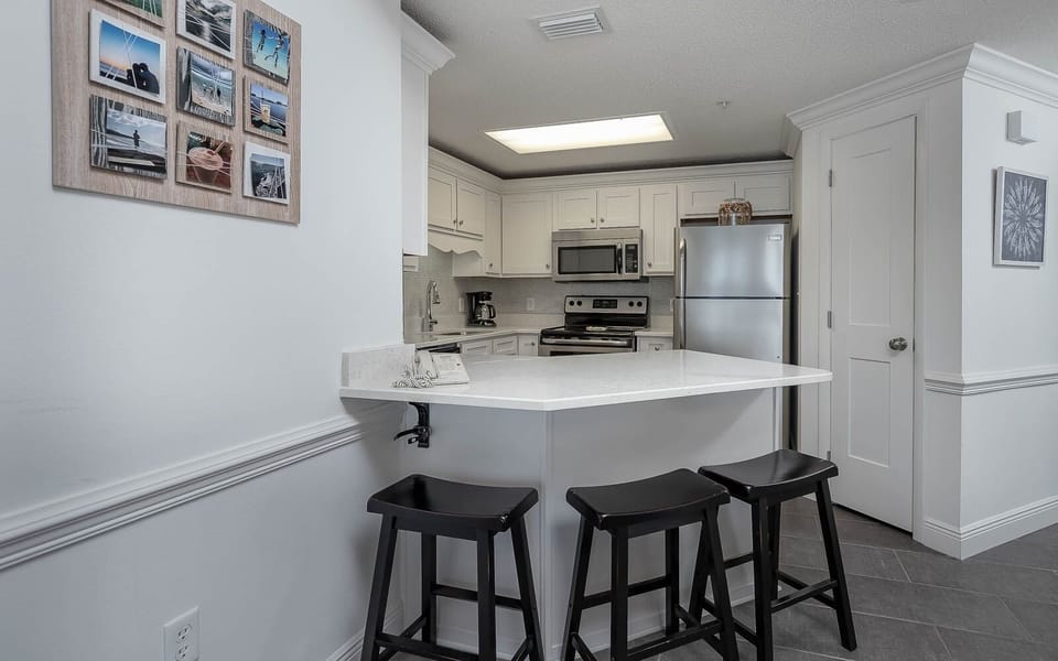 Enjoy meals at the sleek kitchen bar with stainless appliances and stylish decor, perfect for your culinary adventures
