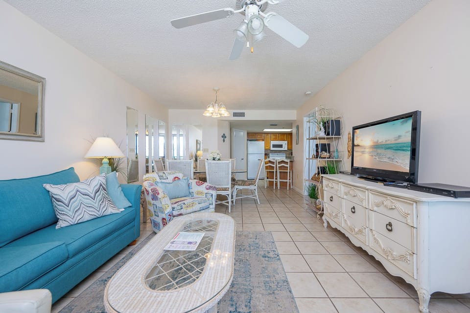 Relax in the inviting living area, featuring a TV, sofa with queen sleeper, and stunning beach views