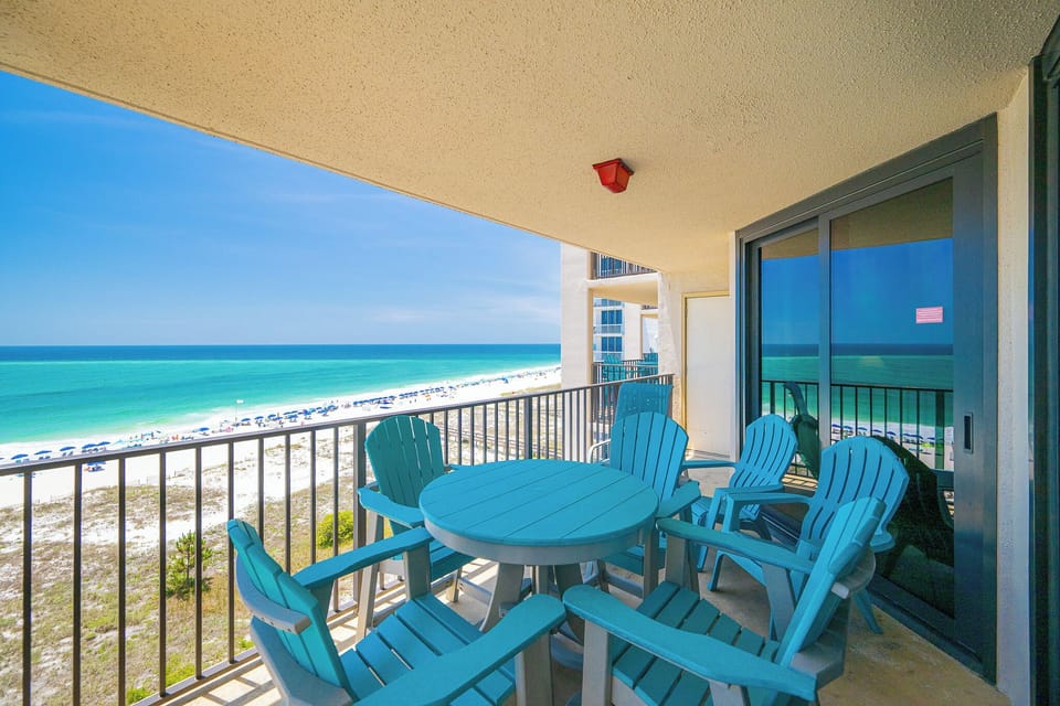 Enjoy the fresh gulf air on the balcony with views of the beach and inviting lounge chairs for relaxation