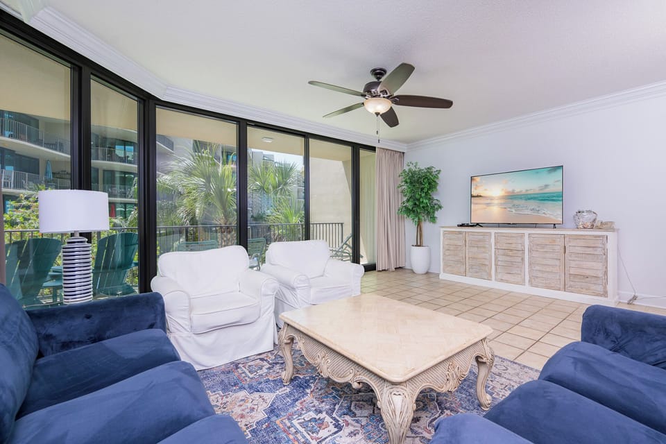 Unwind in the inviting living area, enjoying the gentle breeze and palm views through expansive glass doors