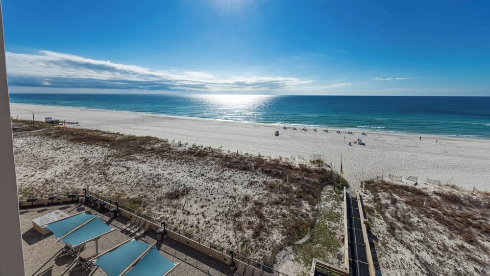 Gaze at the sparkling waters and soft beach from the inviting outdoor seating area below