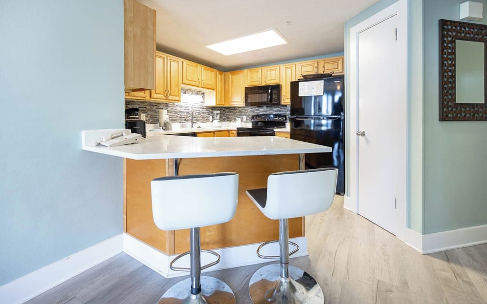 Sit at the sleek bar stools and enjoy a meal in the inviting kitchen with ample counter space and black appliances