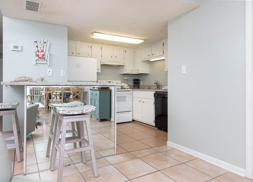 This inviting kitchen features stylish cabinetry, a breakfast bar, and a cozy dining area, perfect for shared meals