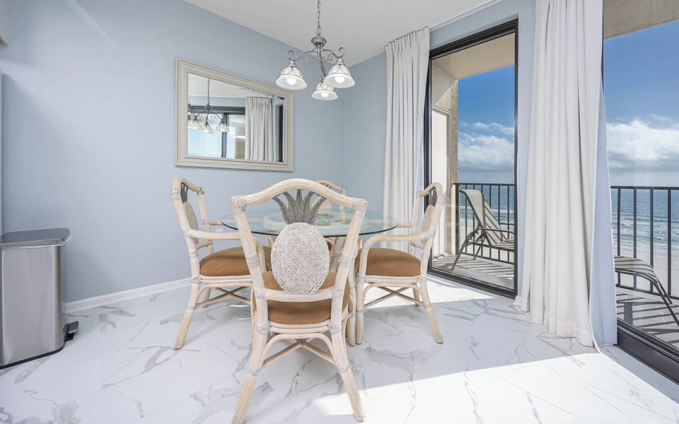 Dine at the glass table while enjoying views of the beach through the large sliding doors