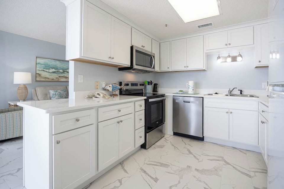 Prepare meals in the sleek kitchen featuring stainless steel appliances and ample counter space for your culinary adventures