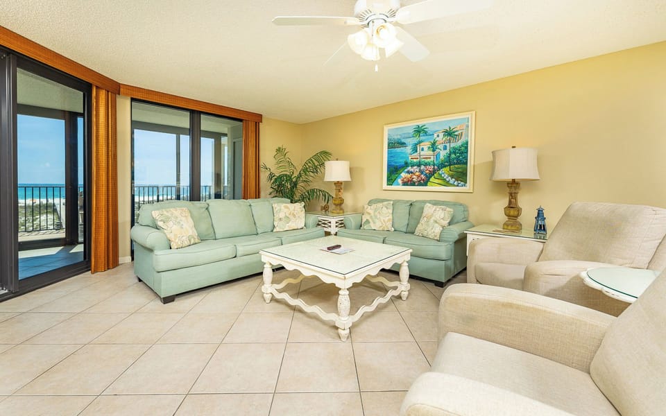 Soft couches invite you to relax in the living room while coastal breeze drifts through the sliding doors