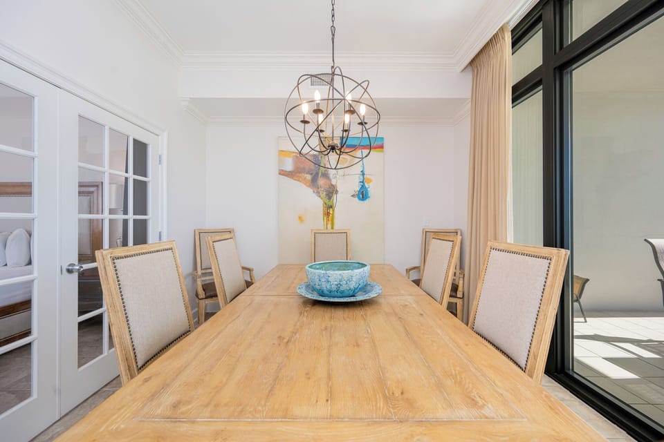 Gather around the spacious dining table, sharing stories and laughter amidst the beach vibe and warm decor